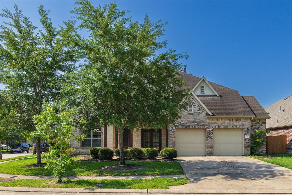 a front view of a house with a garden and trees