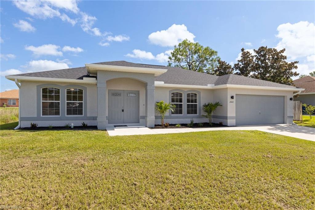 View of front of property with a garage and a front yard