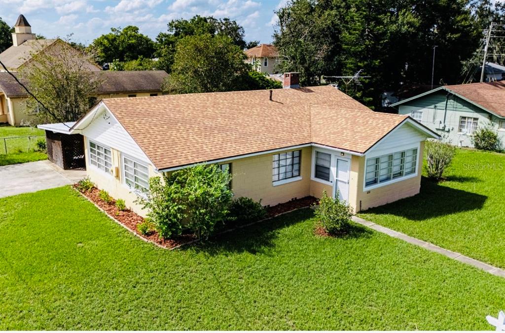 a aerial view of a house with a yard table and chairs