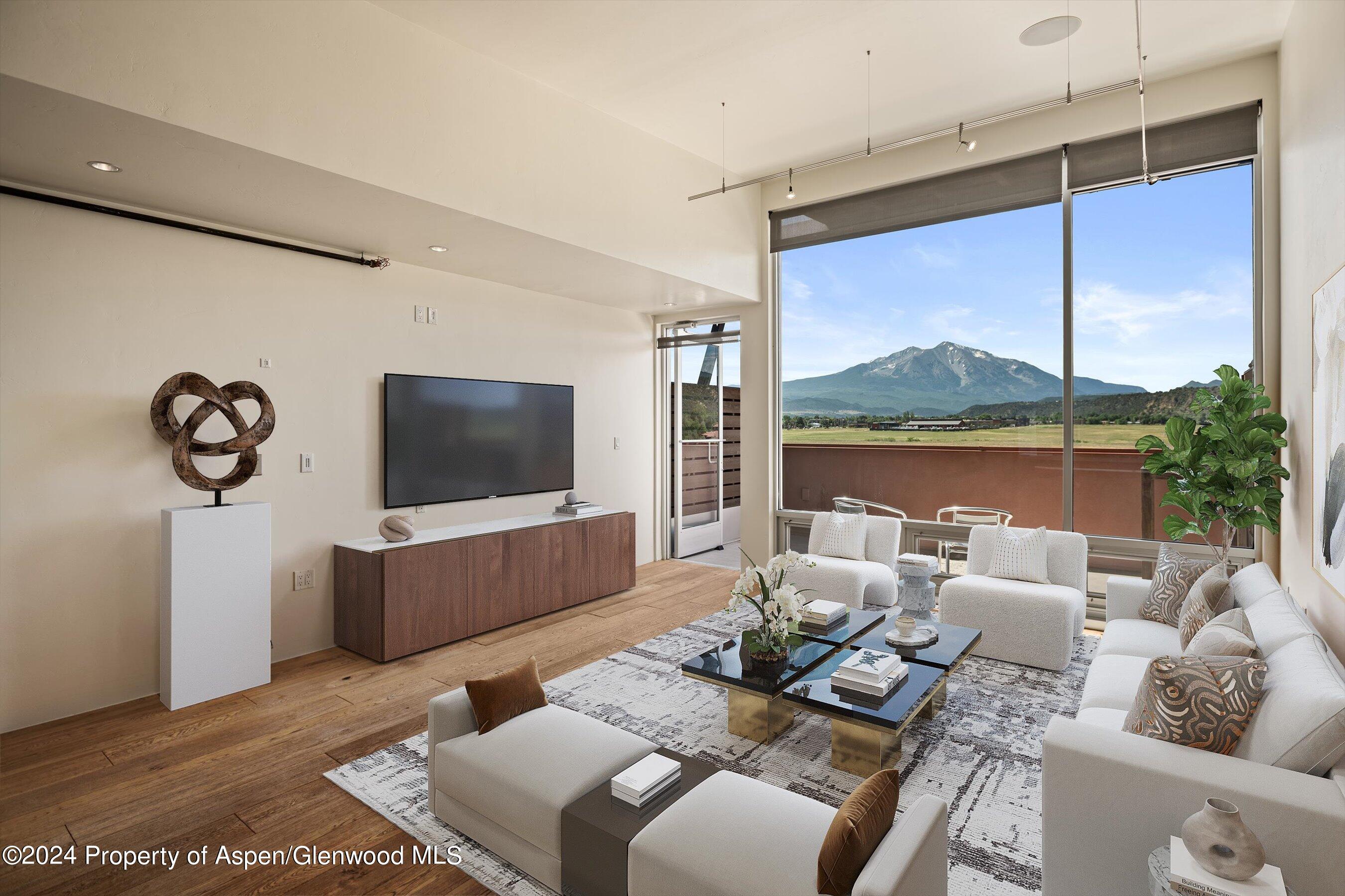 a living room with furniture a flat screen tv and a large window