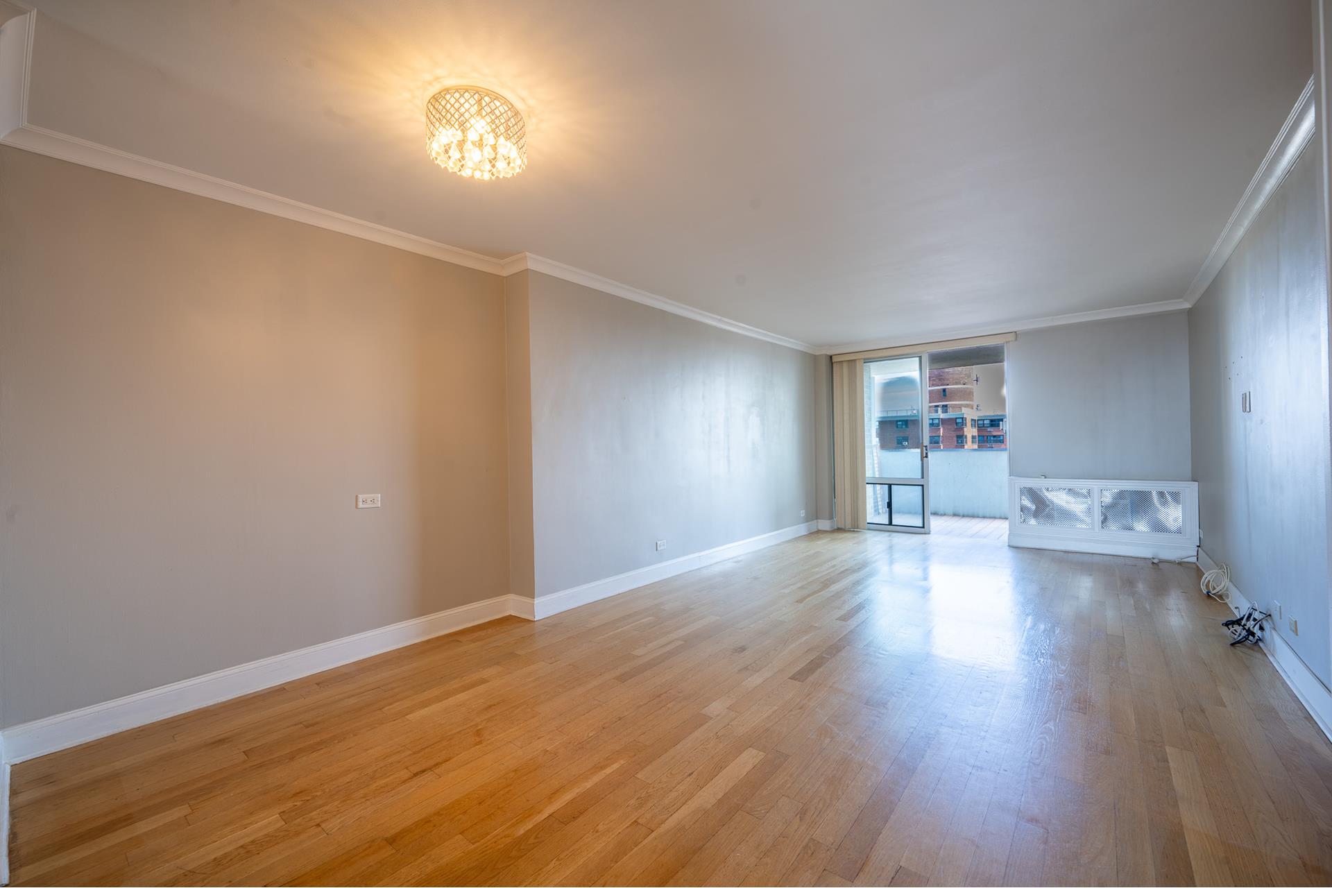 a view of empty room with wooden floor