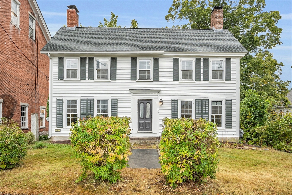 a front view of house with yard and trees around