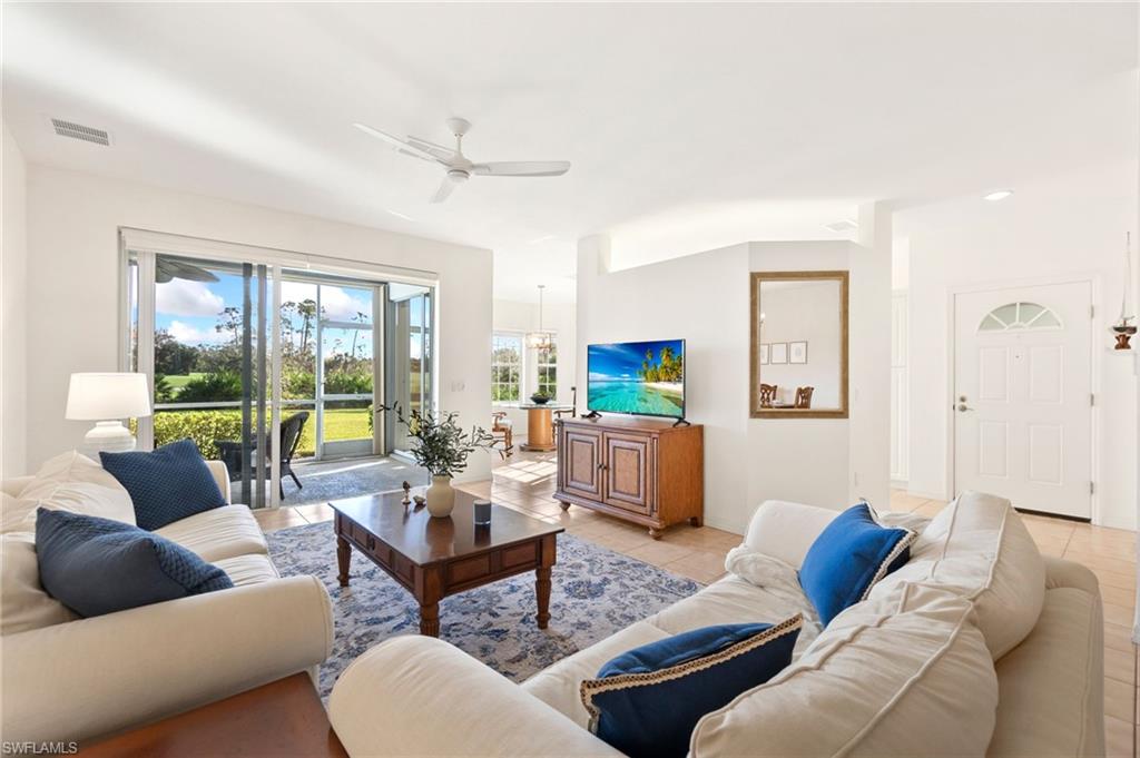 Living room with ceiling fan and light tile patterned floors