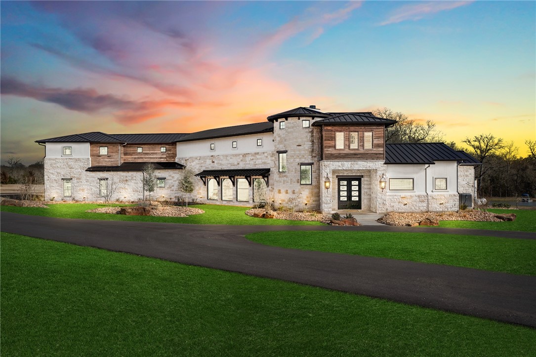 a view of a big house with a big yard plants and large trees