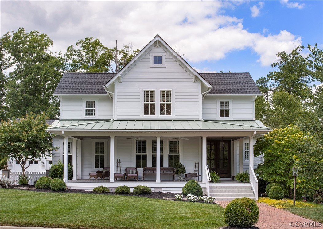 a front view of a house with garden and trees