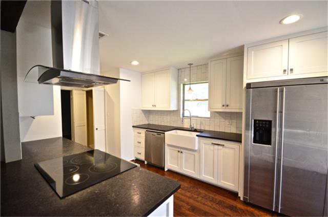 a kitchen with stainless steel appliances granite countertop a sink a stove and a refrigerator