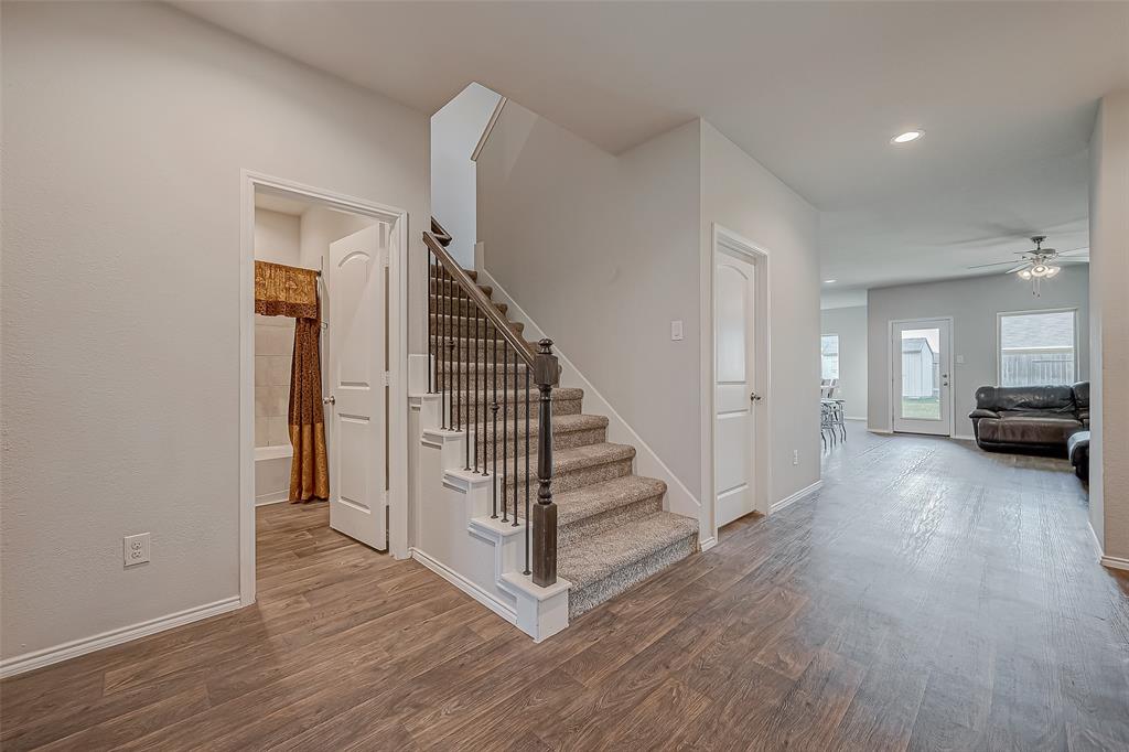 a view of a livingroom with wooden floor and stairs