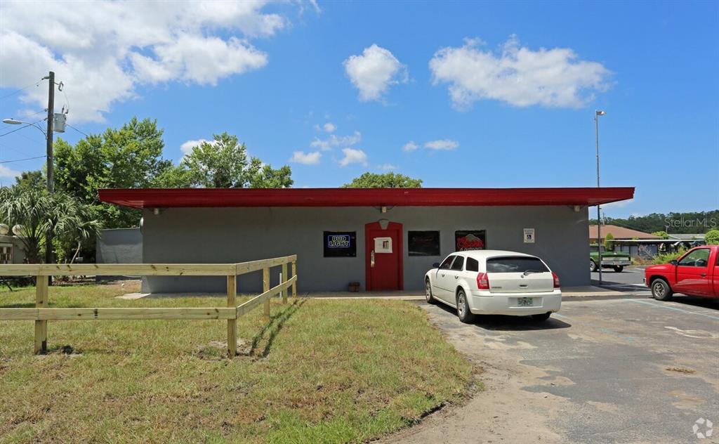 a front view of a house with parking space and a car parked in it