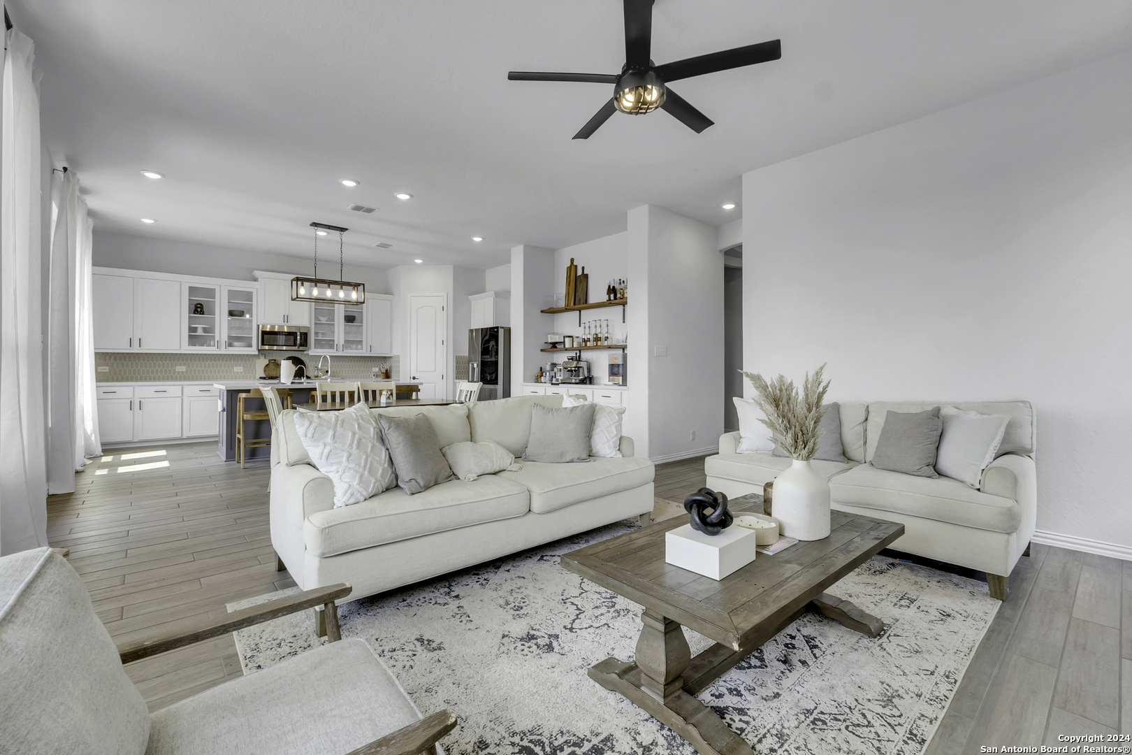 a living room with furniture and a view of kitchen