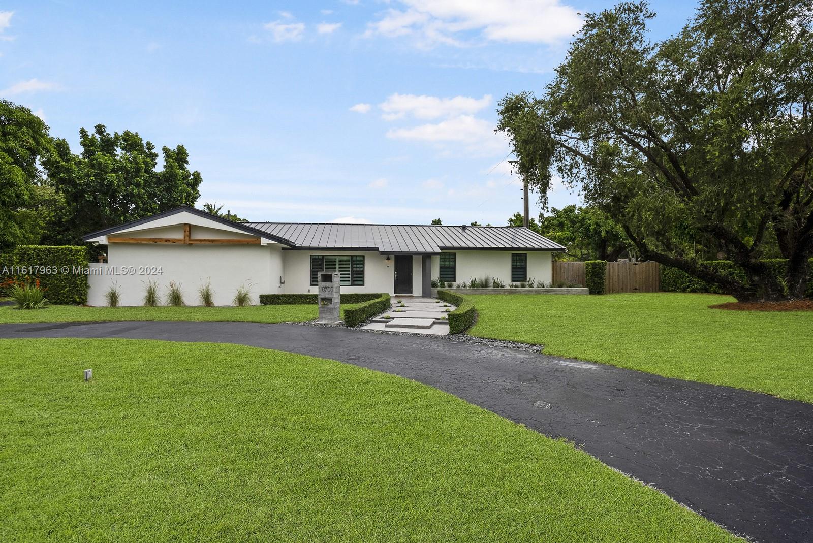 a front view of a house with yard and green space