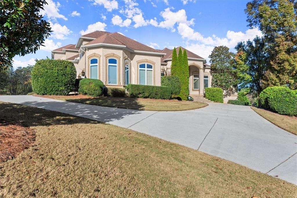 a front view of a house with a yard and trees