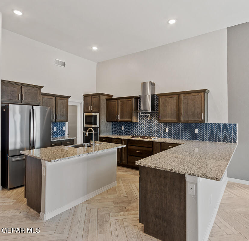 a kitchen with stainless steel appliances granite countertop a sink stove microwave and refrigerator