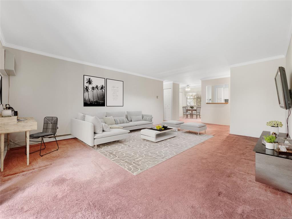 Carpeted living room featuring crown molding