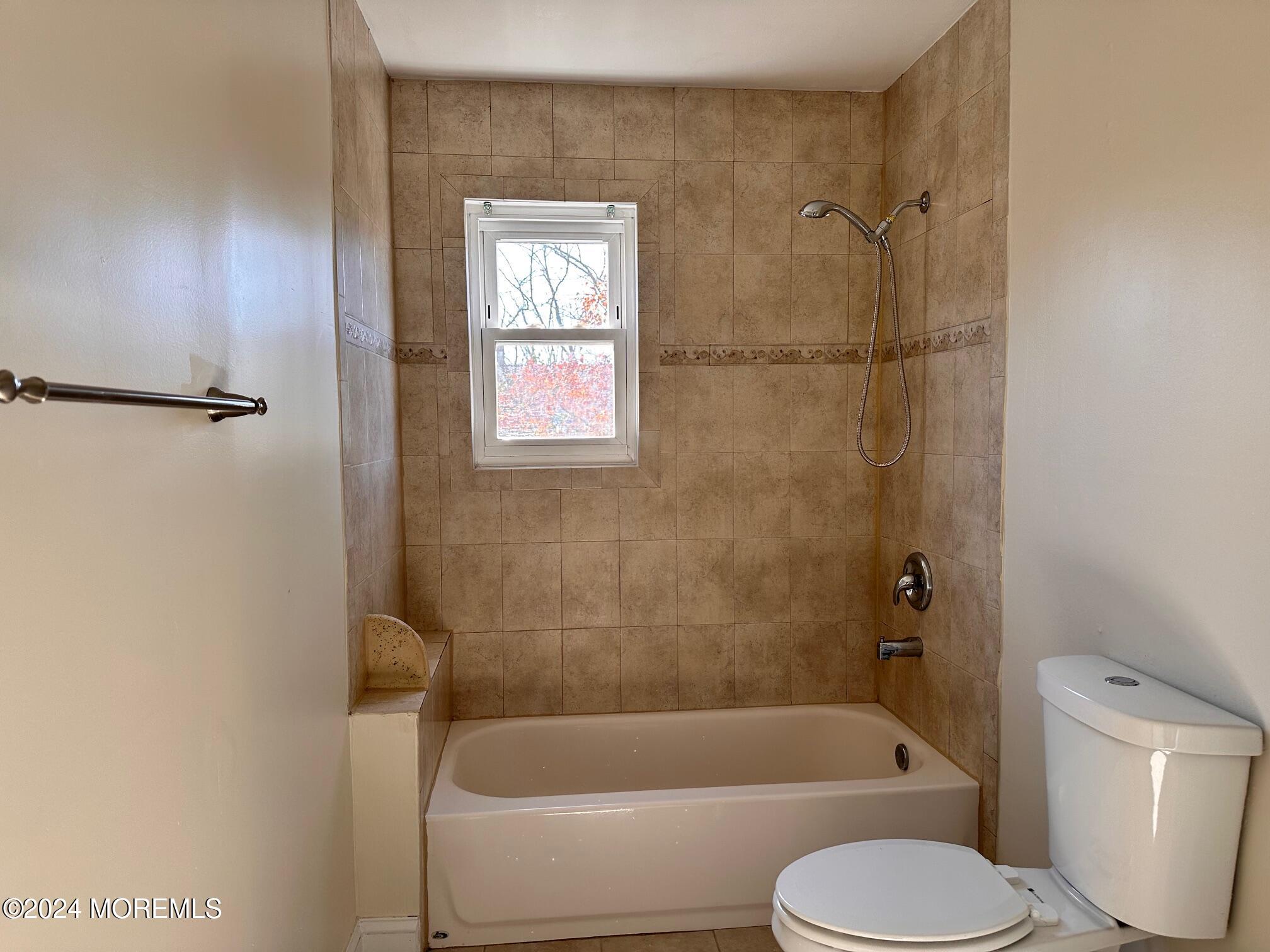 a bathroom with a toilet and a bath tub