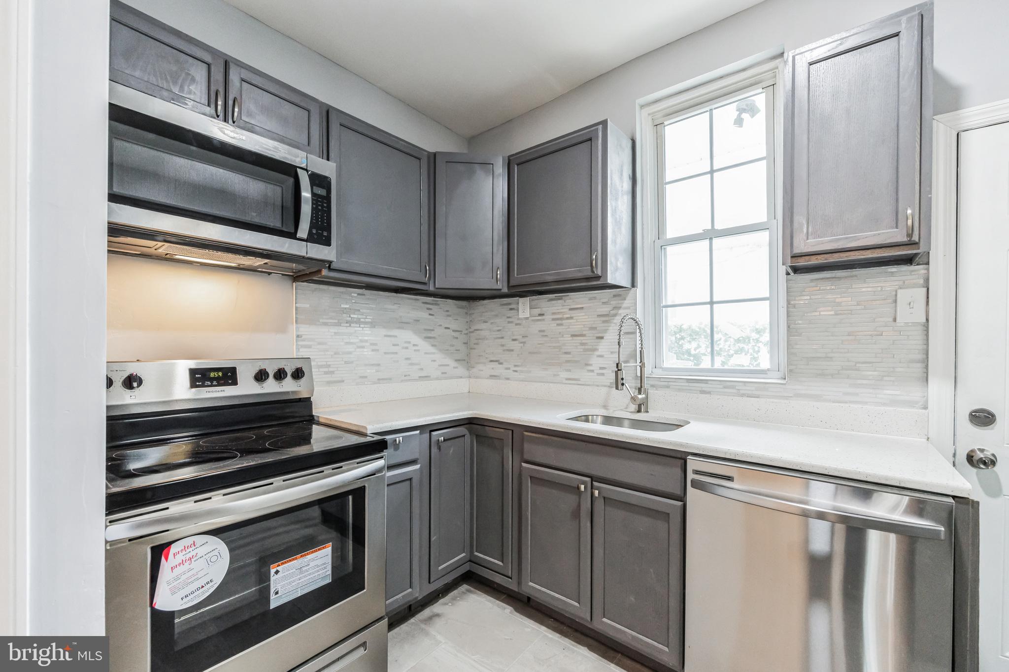 a kitchen with stainless steel appliances a stove sink and cabinets