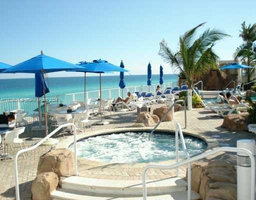 a view of a swimming pool with a lawn chairs under an umbrella