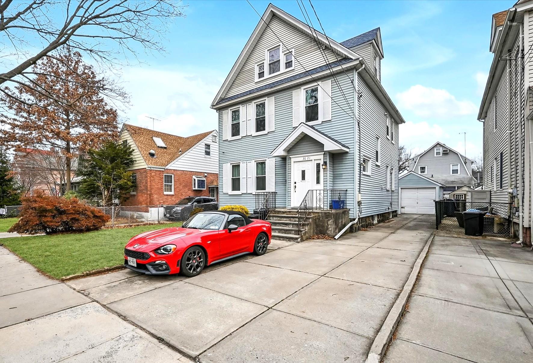 Front facade featuring a garage, an outbuilding, and a front lawn