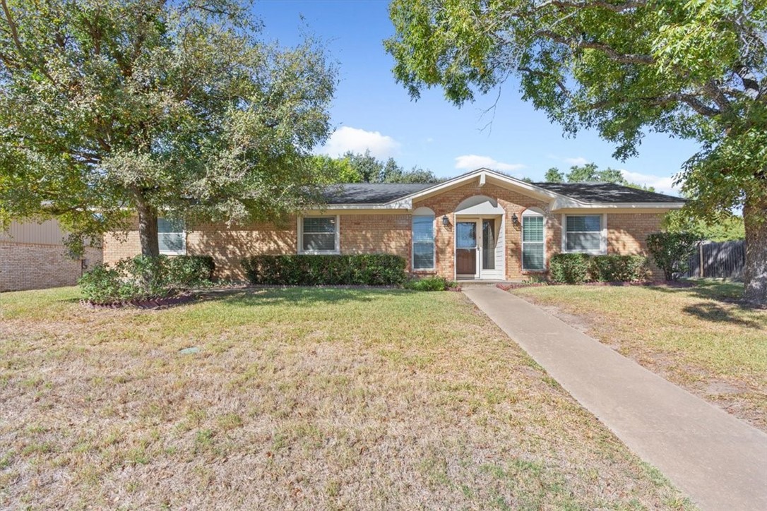 a front view of house with yard and trees around