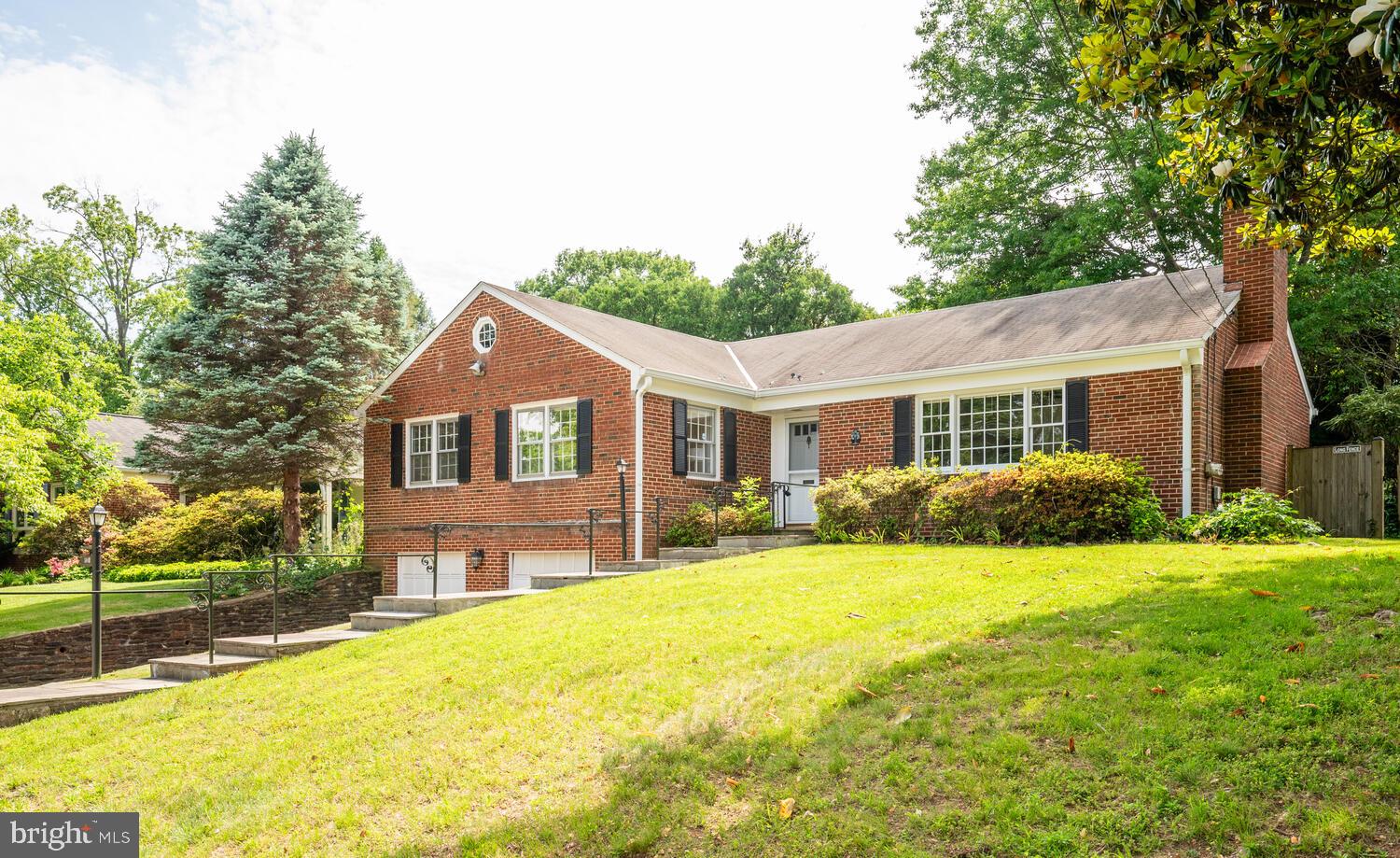 a front view of a house with a yard and trees