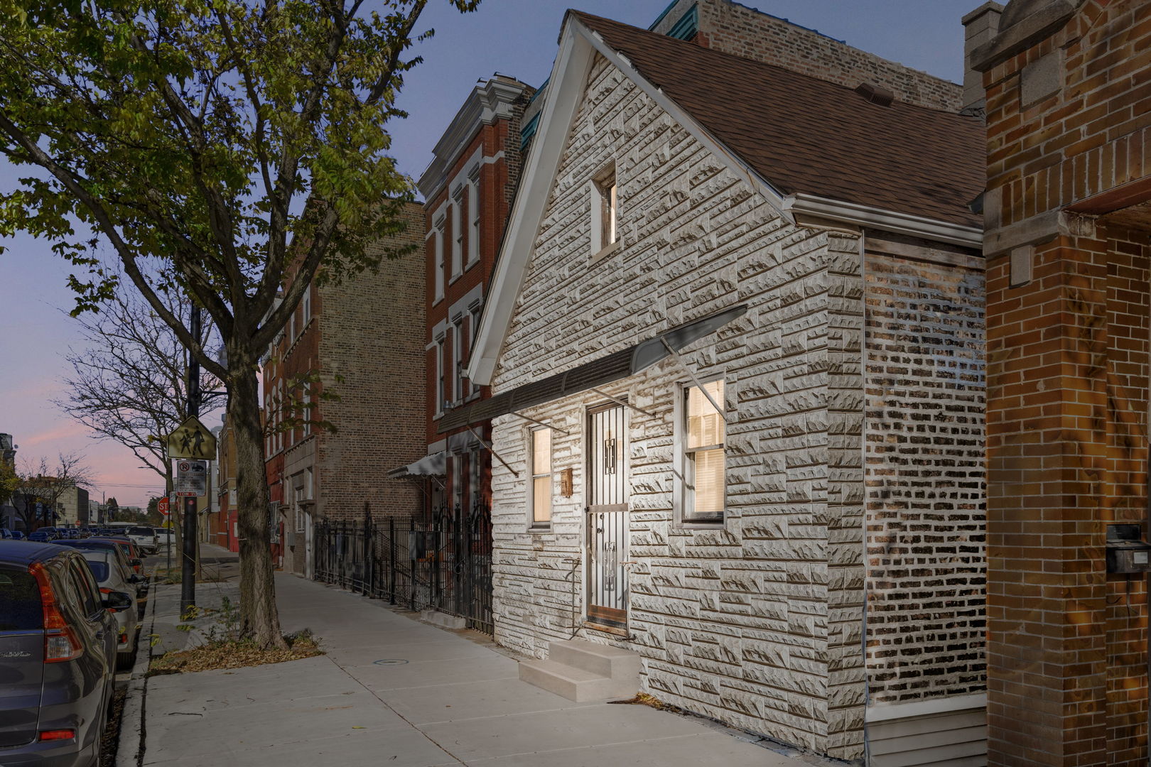 a view of a brick house with a large tree