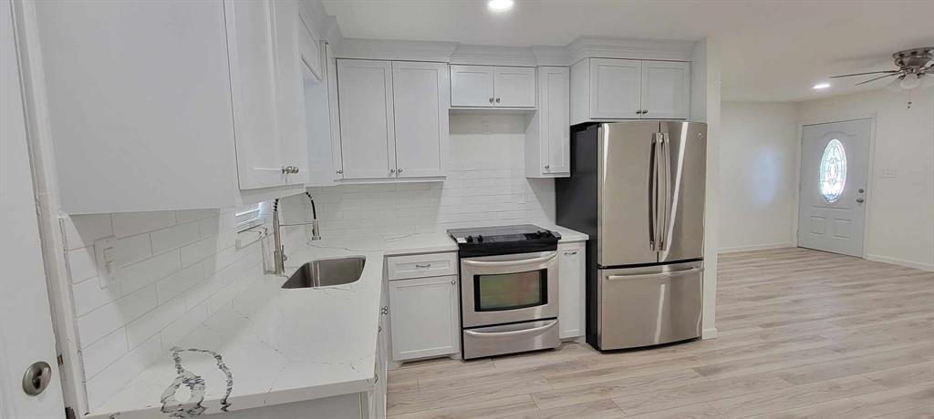 a kitchen with stainless steel appliances granite countertop a refrigerator sink and stove