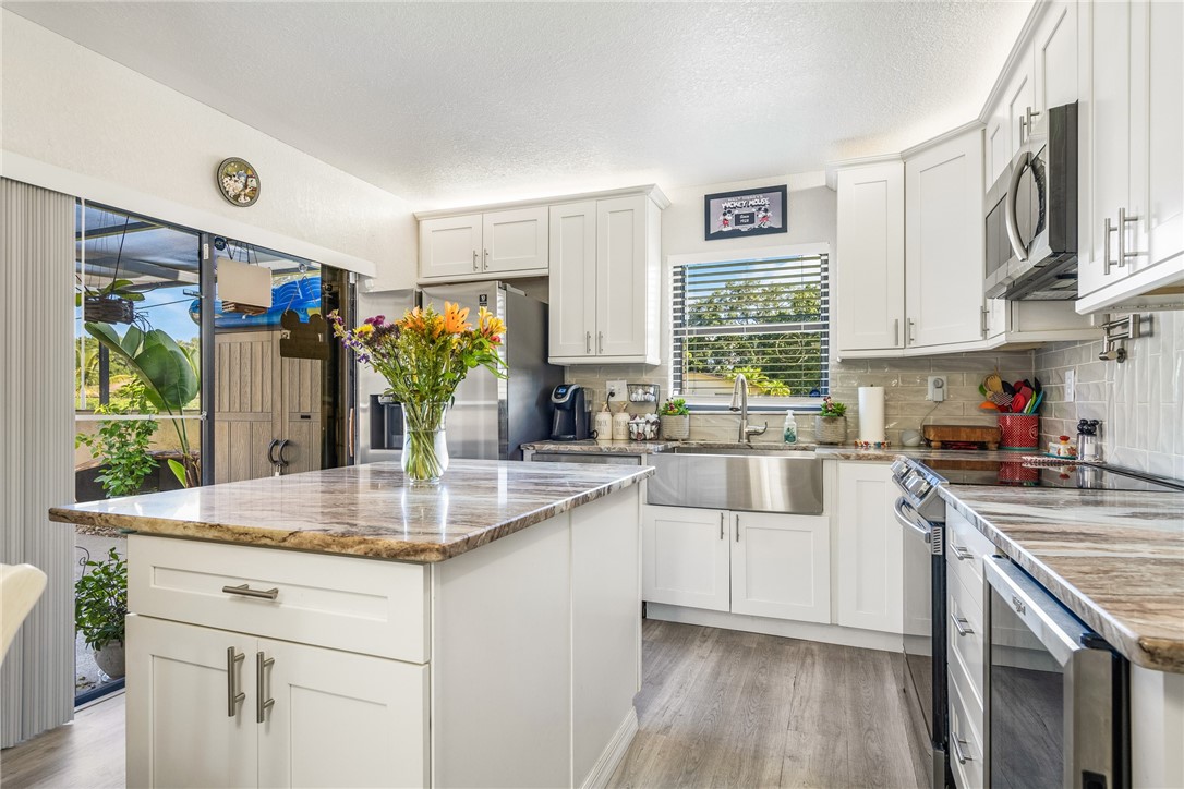 a kitchen with stainless steel appliances granite countertop a sink and cabinets