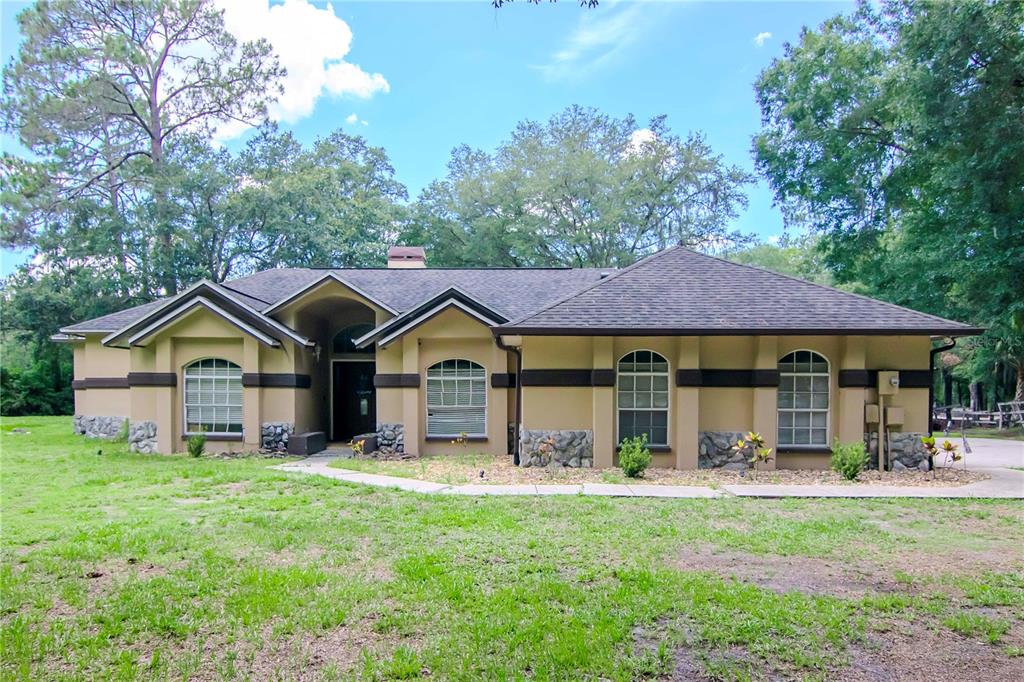 a front view of a house with yard and green space