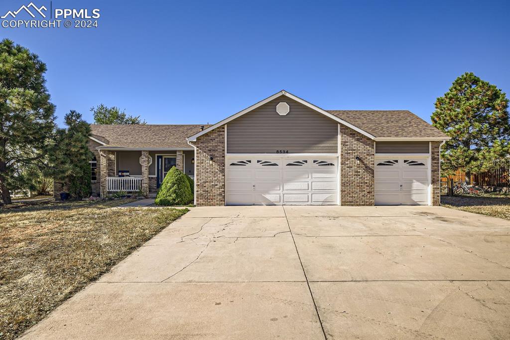 Ranch-style house with covered porch and a garage