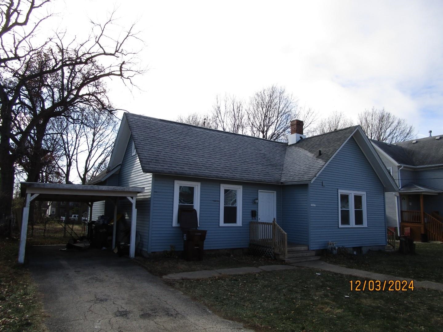 a front view of house with yard and trees around