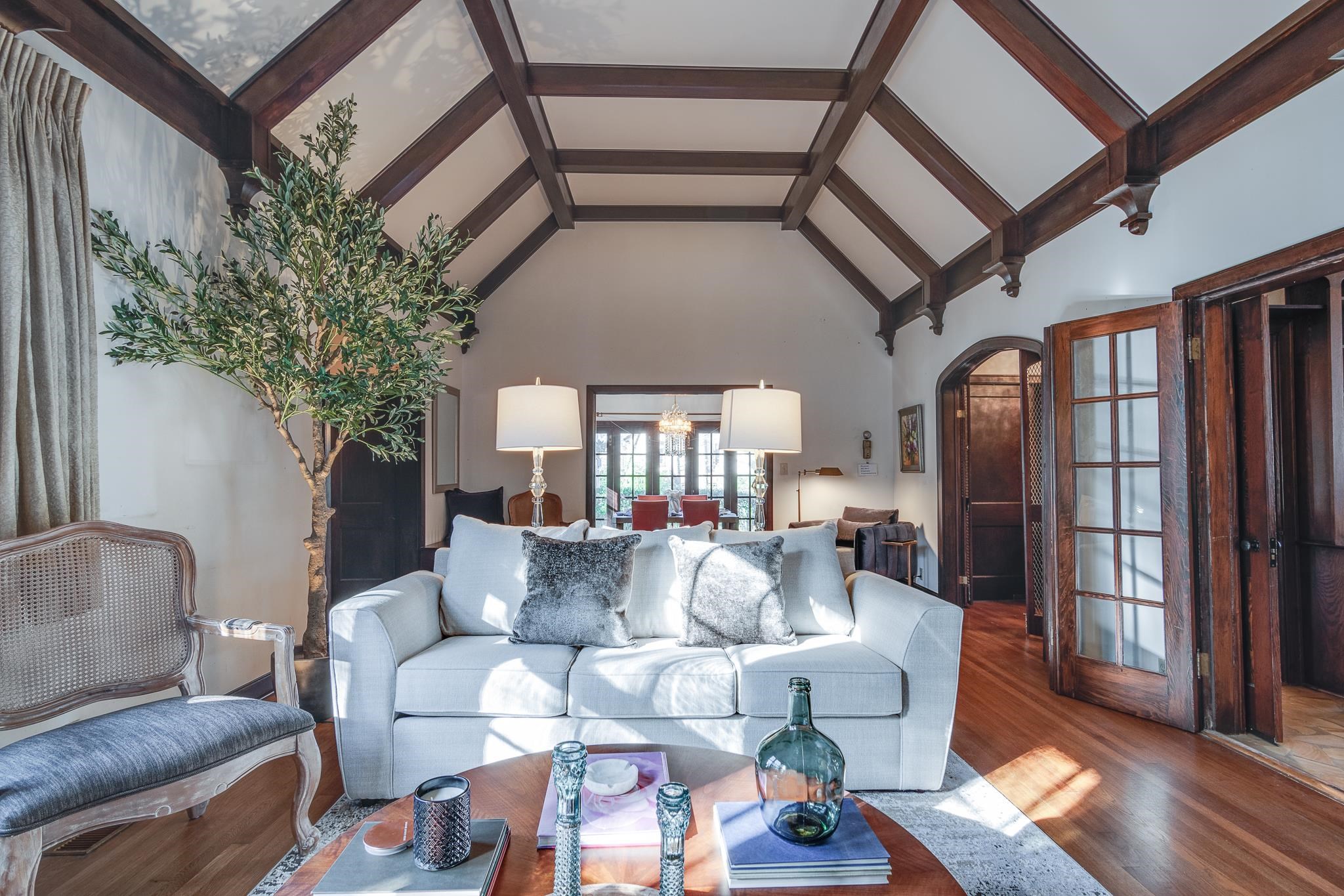 Living room with beamed ceiling, hardwood / wood-style flooring, and high vaulted ceiling