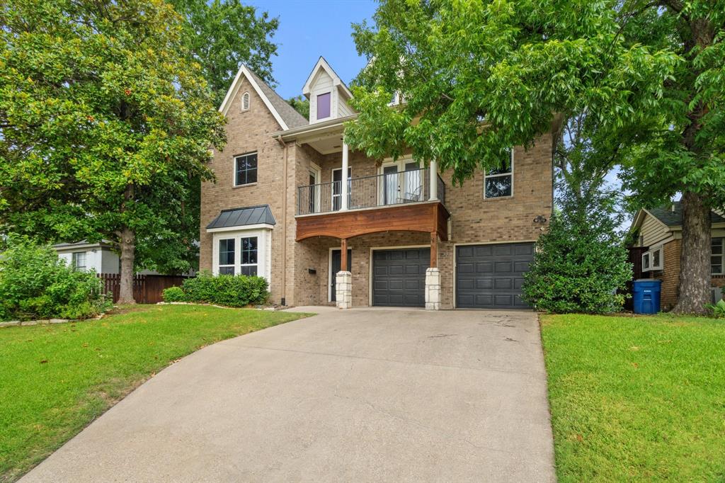 a front view of a house with yard and green space