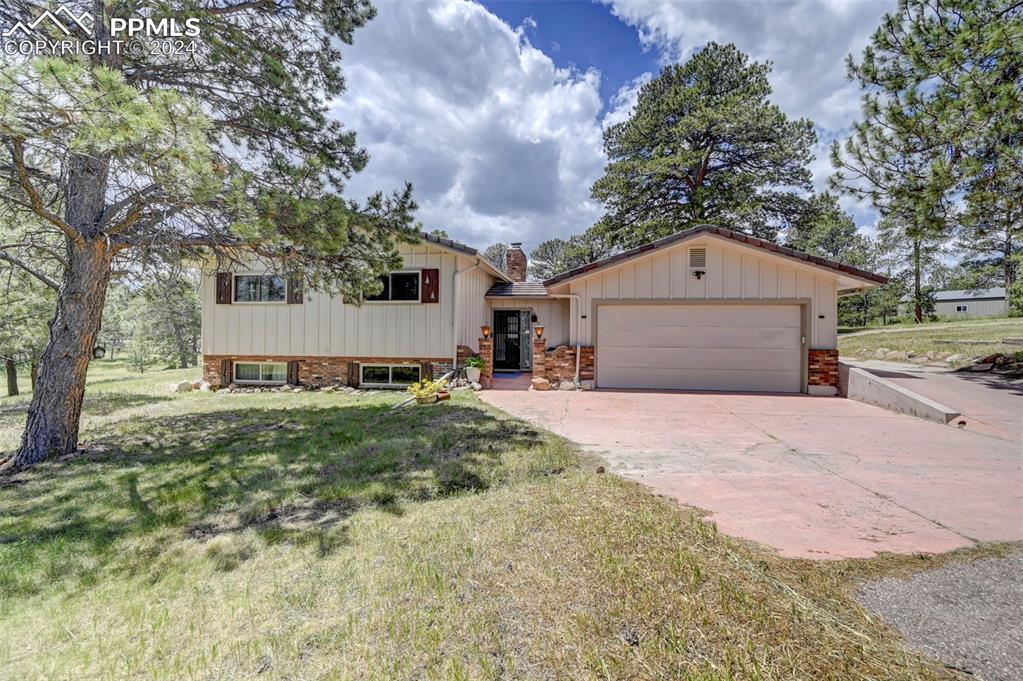 Bi level home with a front lawn and a garage