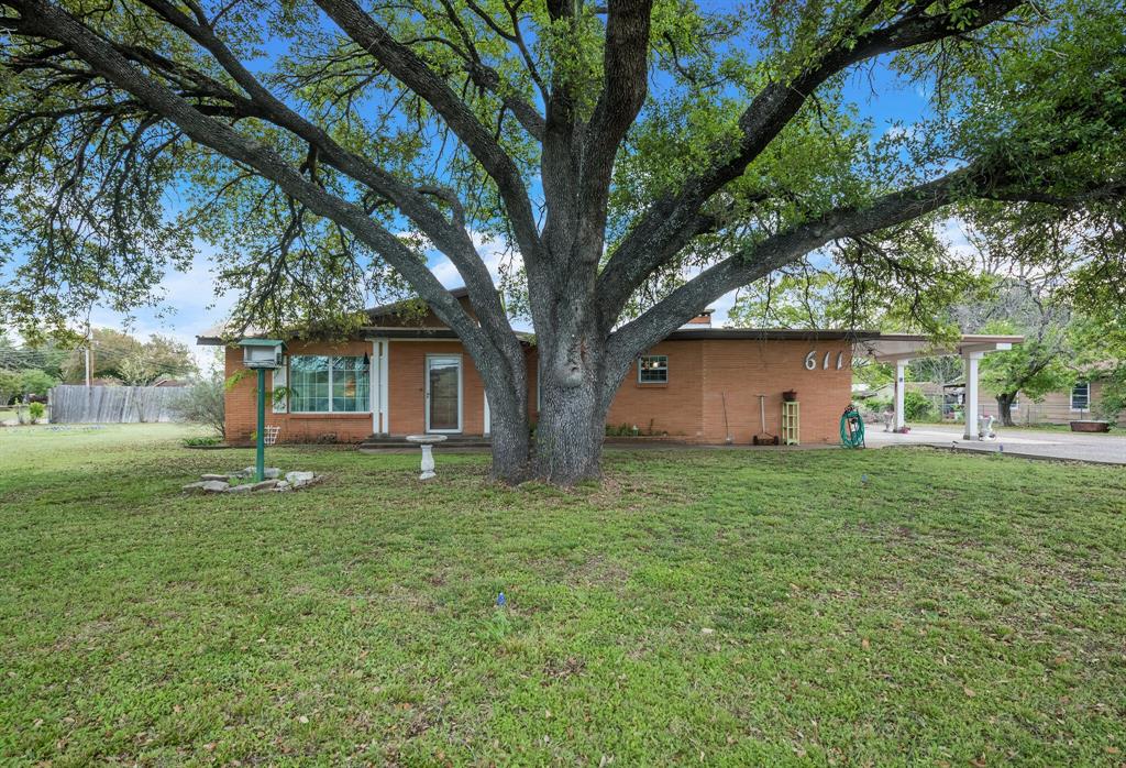 a view of backyard of house with green space