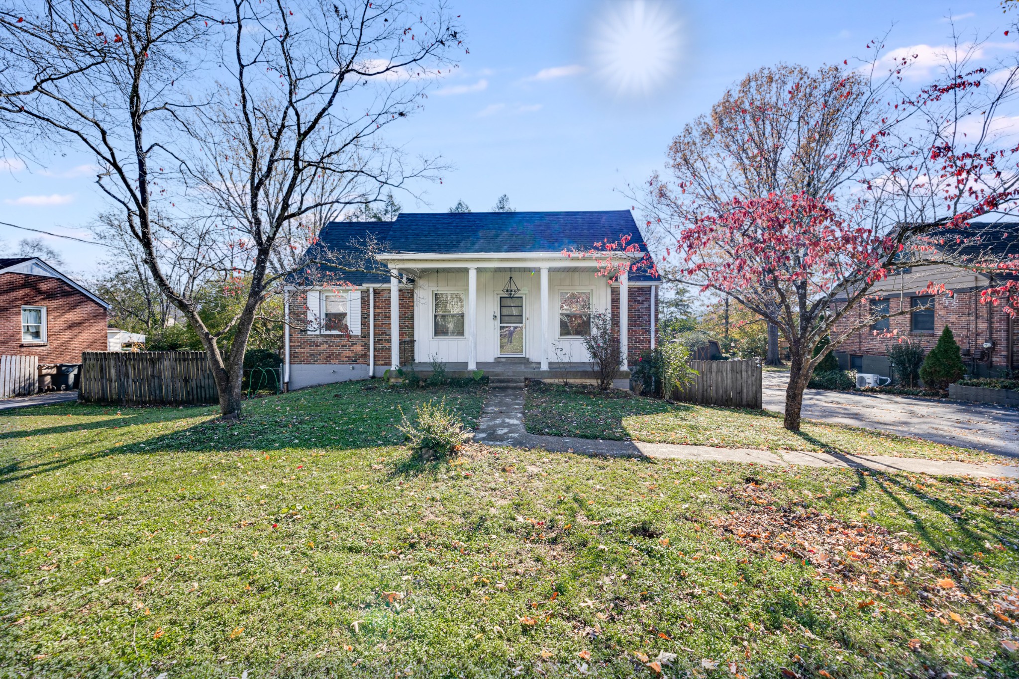 a front view of a house with a yard and large trees