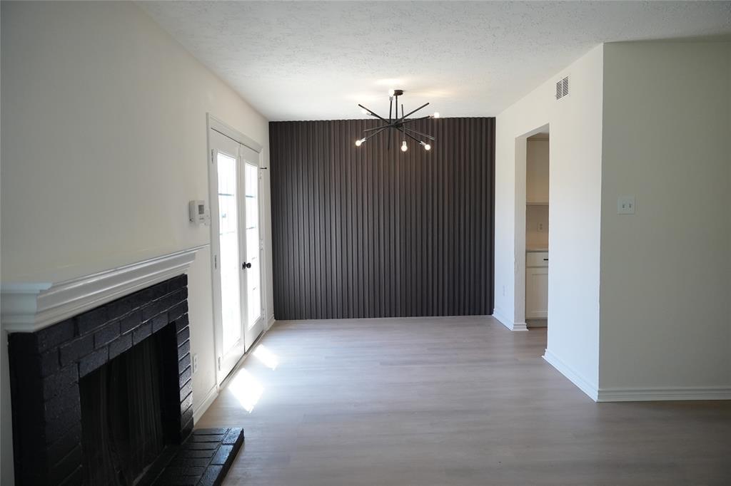 an empty room with windows and fireplace