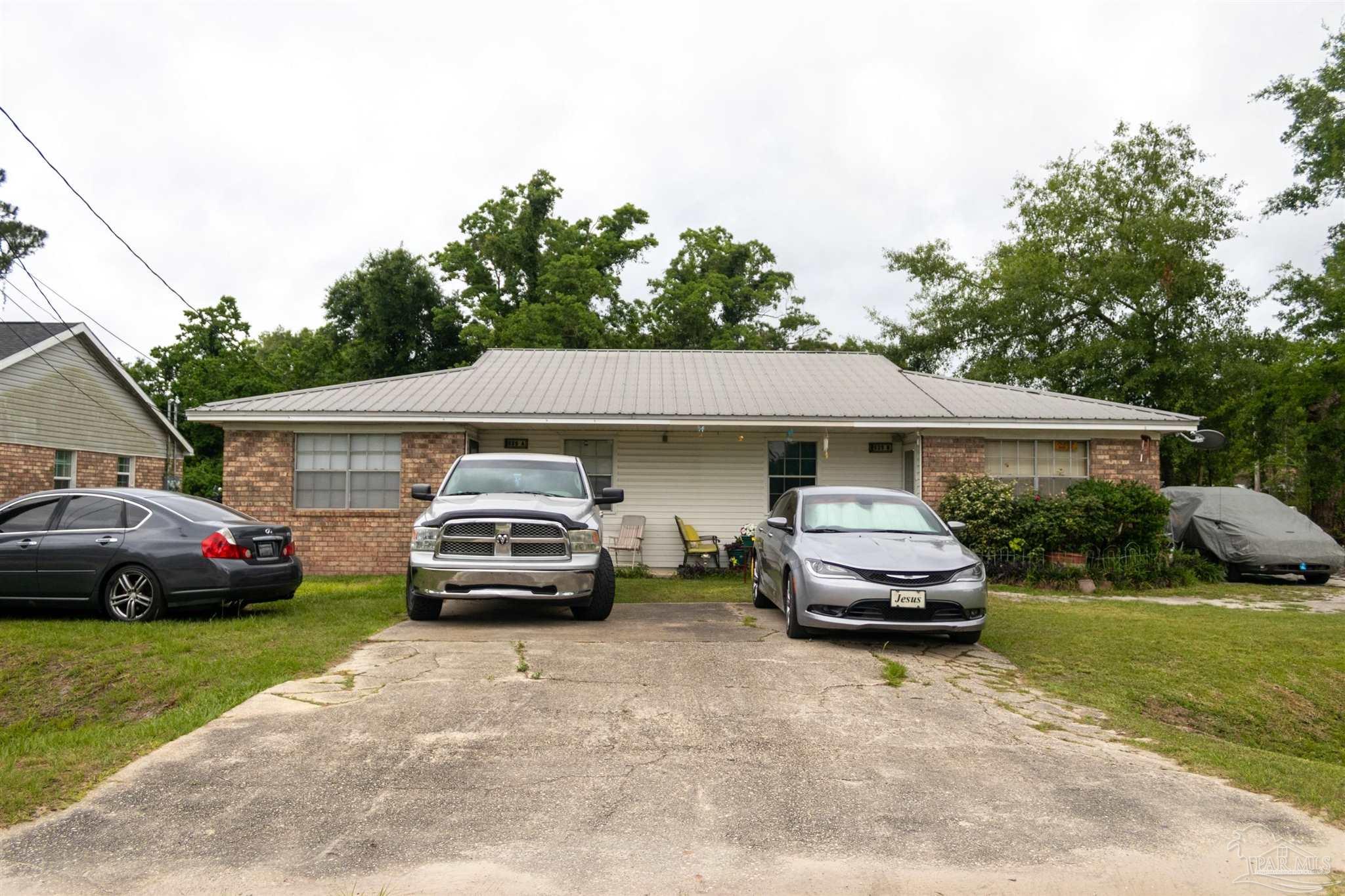 a front view of a house with cars parked