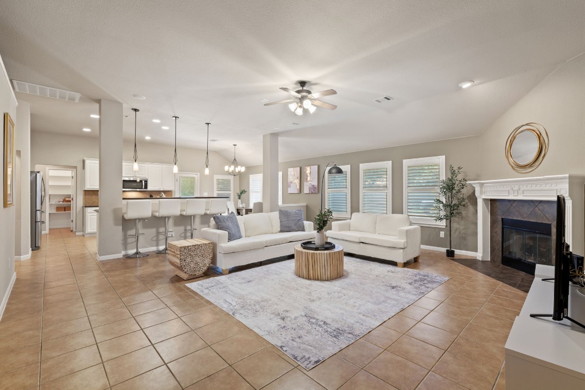 a living room with furniture a fireplace and a chandelier