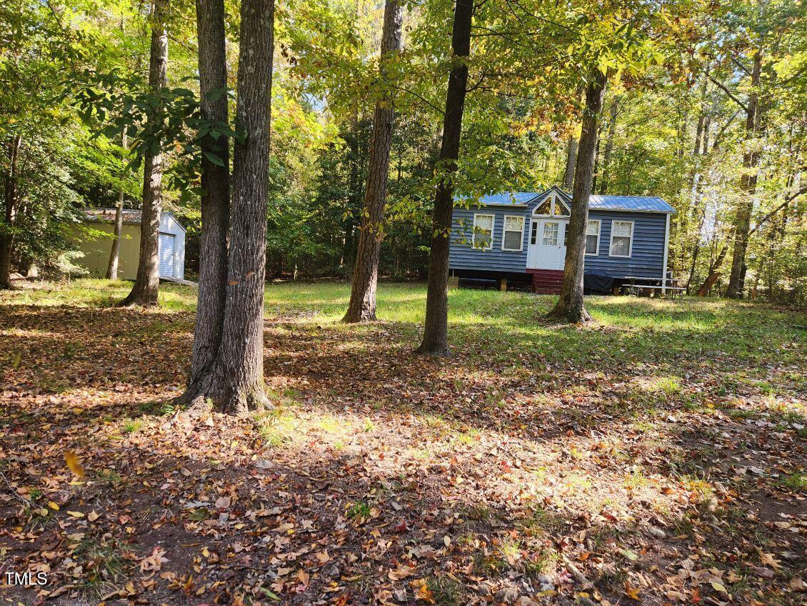 a view of a house with a yard and tree s