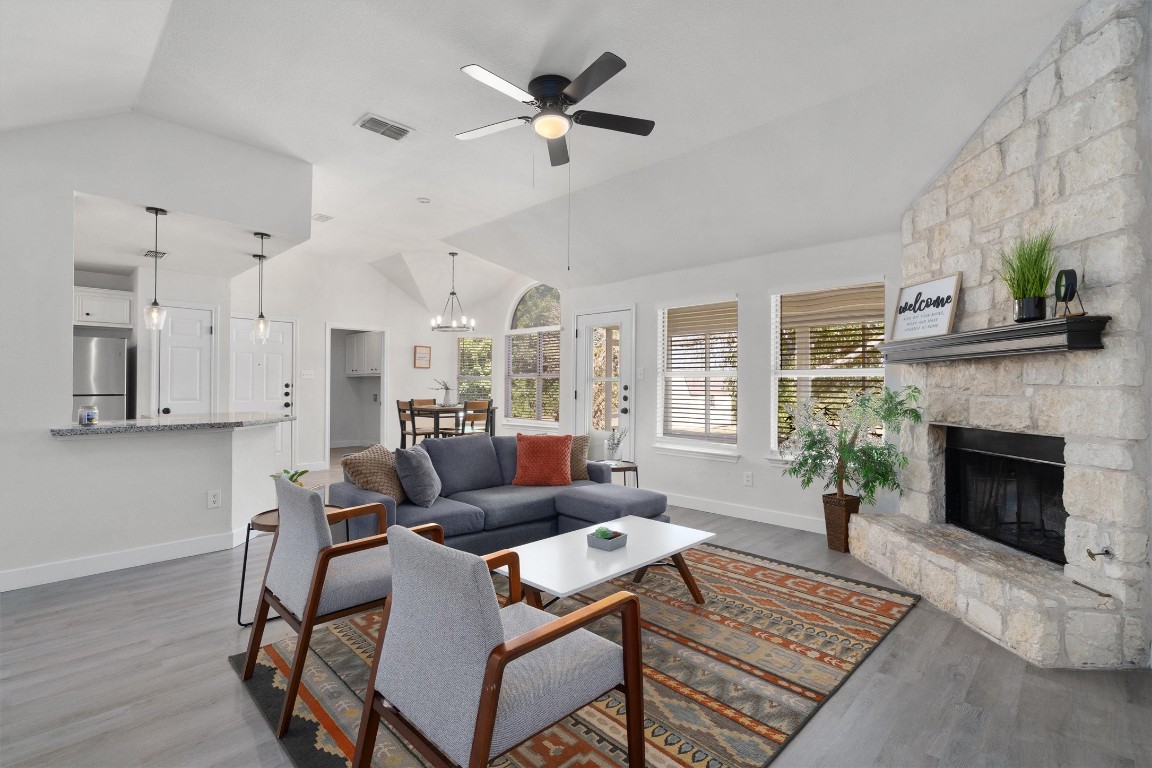 a living room with furniture a fireplace and a chandelier