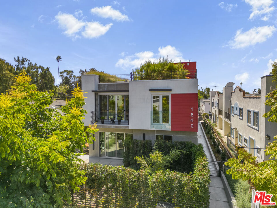 a front view of a multi story residential apartment building with yard and parking space