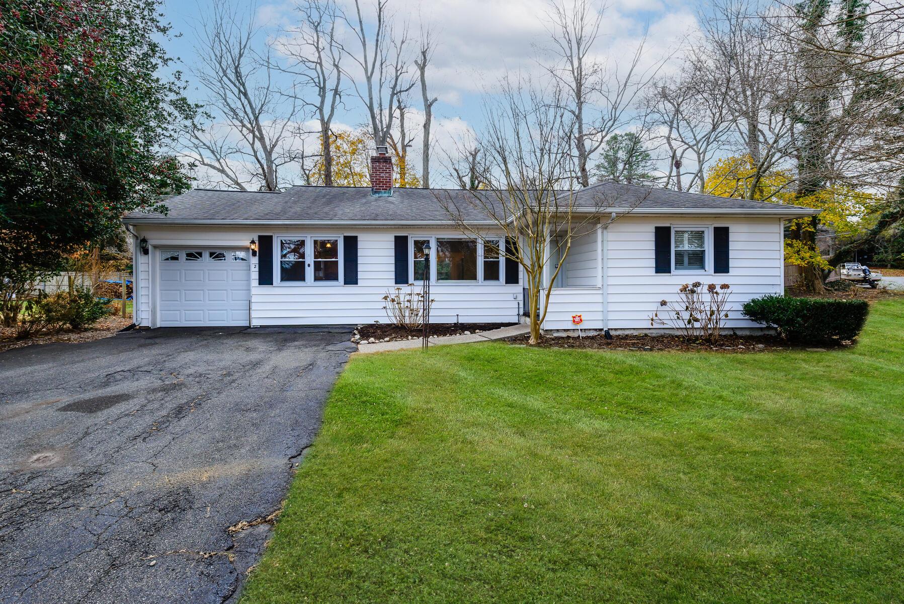 Single story home featuring a garage and a front yard