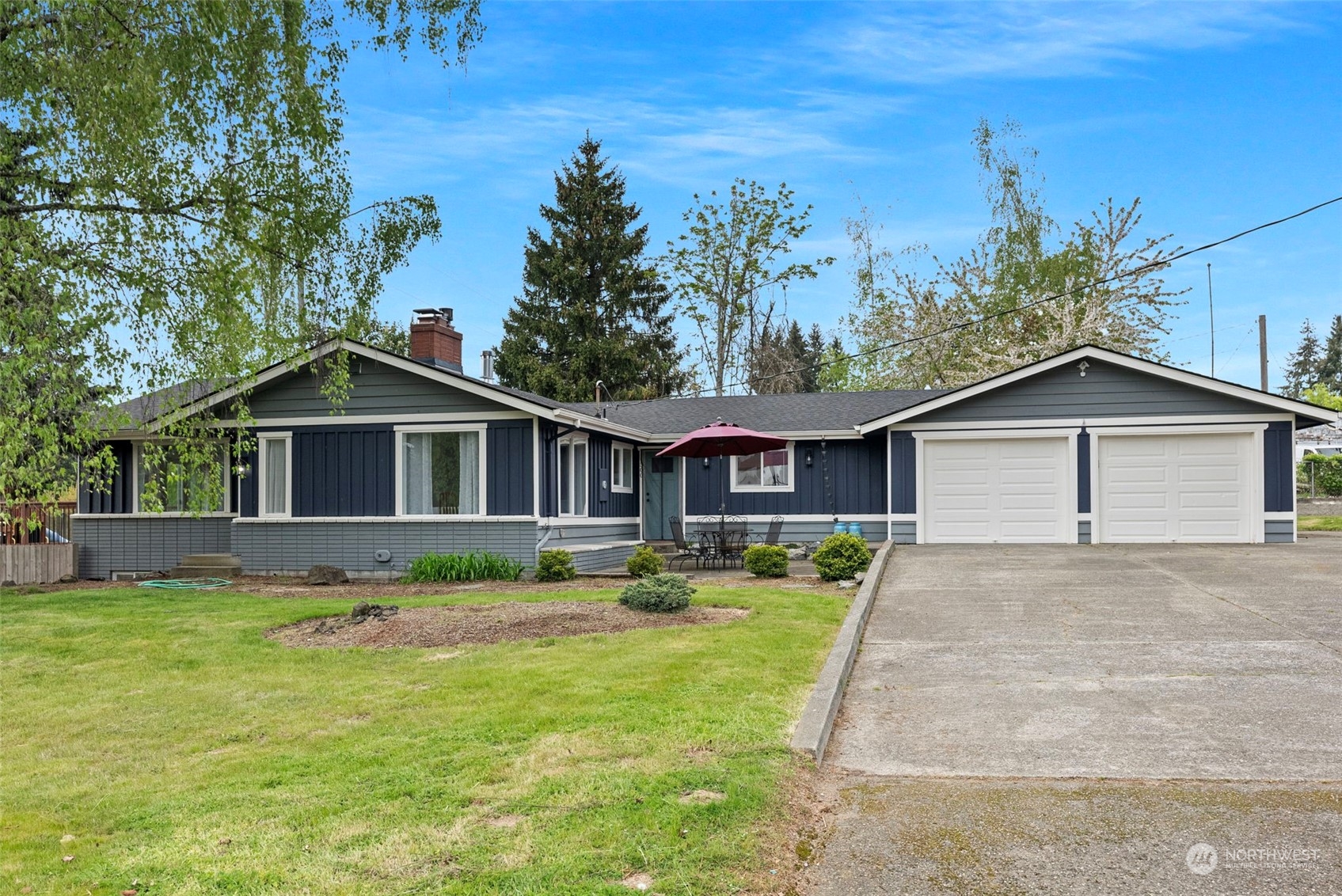 a front view of house with yard and trees in the background