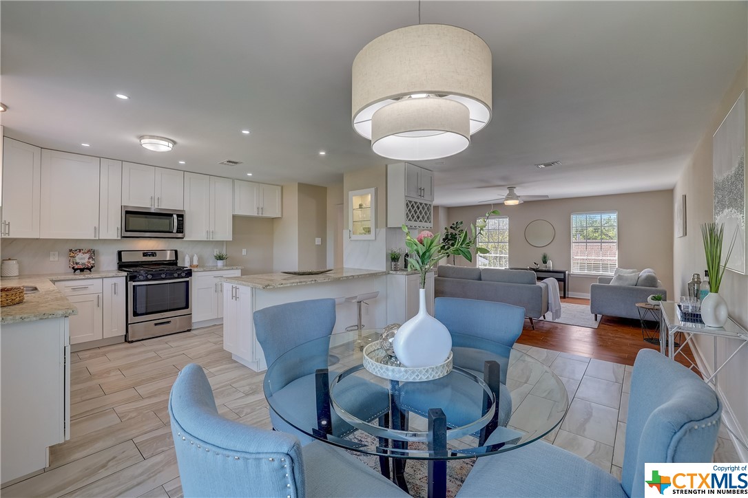 an open kitchen with dining table and wooden floor