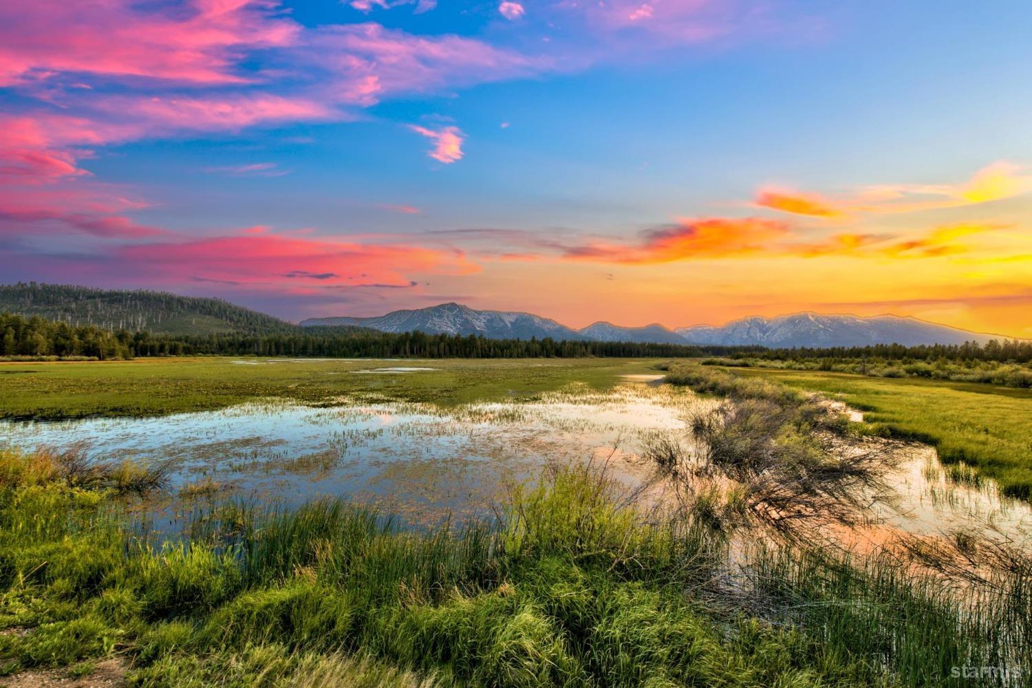 a view of lake with sunset in background