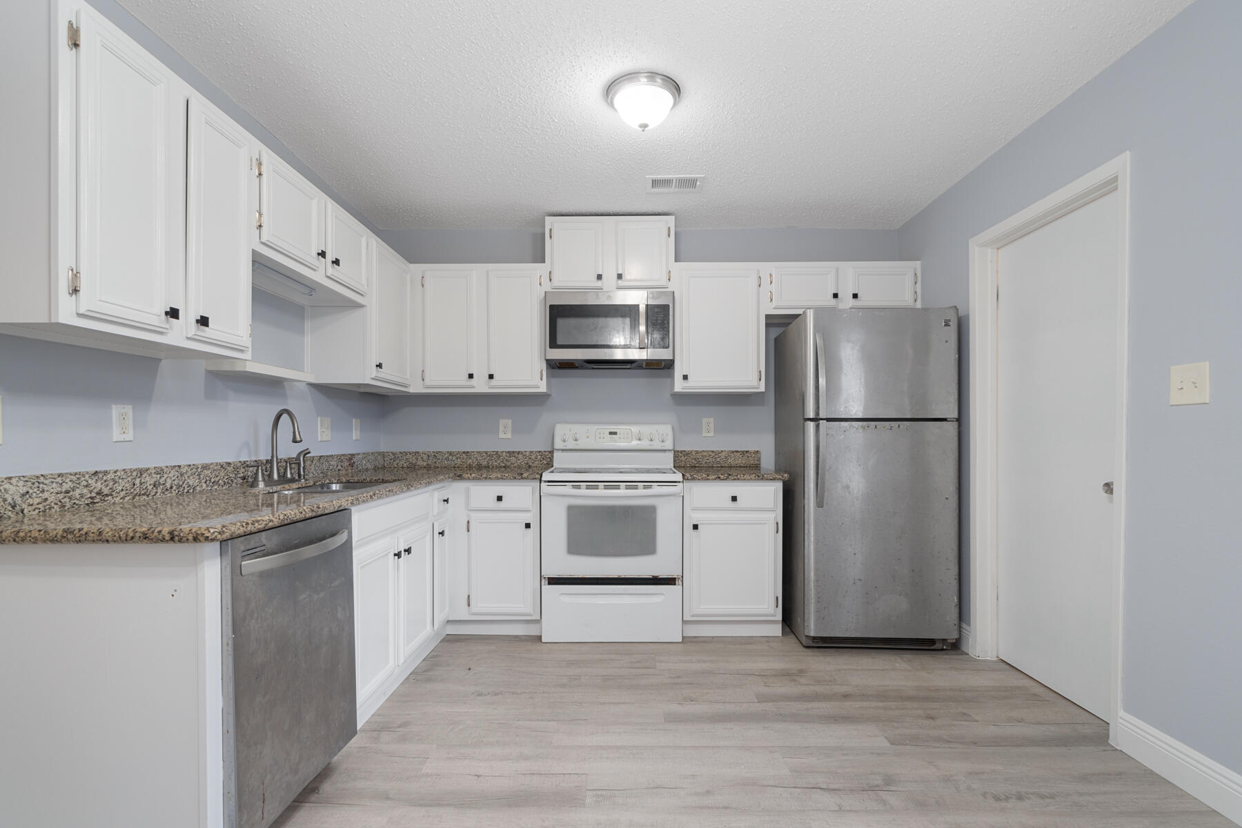 a kitchen with stainless steel appliances granite countertop a refrigerator stove a sink and dishwasher