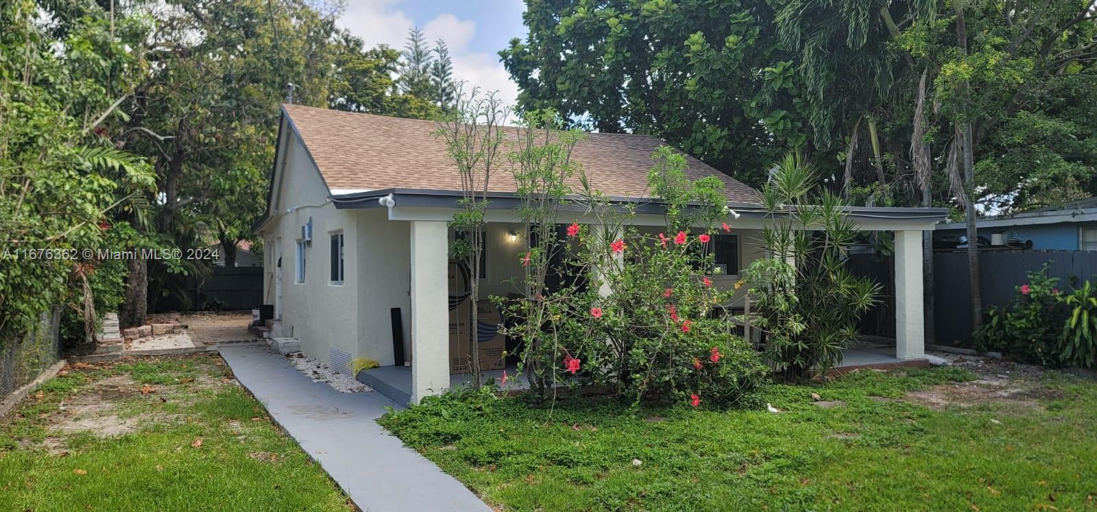 a view of a house with brick walls and a yard with plants