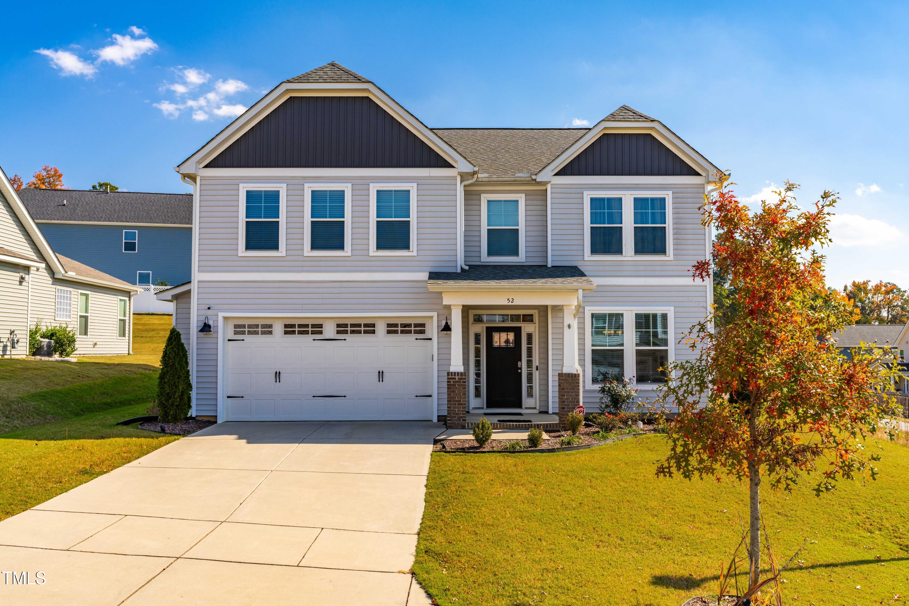 a front view of a house with yard and garage