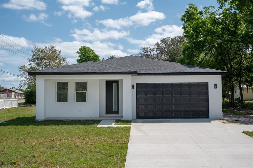 a front view of a house with a yard and garage