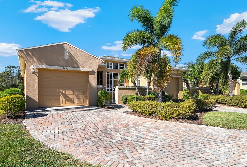 a front view of a house with a yard and potted plants