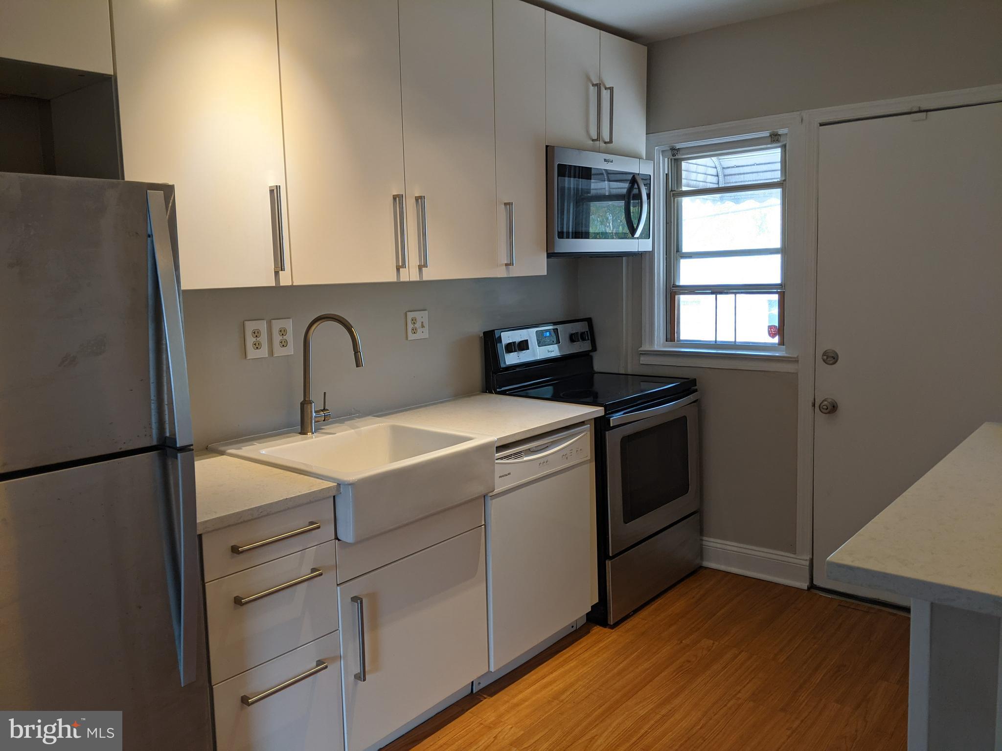 a kitchen with a refrigerator sink and cabinets